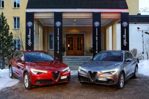 Roter und Silbriger Alfa Romeo Stelvio von vorne stehend auf Hof.