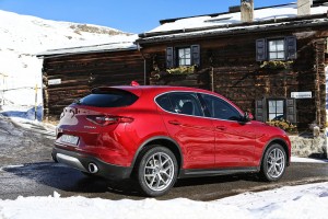 Roter Alfa Romeo Stelvio seitlich hinten stehend auf Schnee