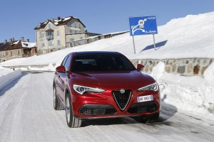 Roter Alfa Romeo Stelvio von vorne fahrend auf Schnee